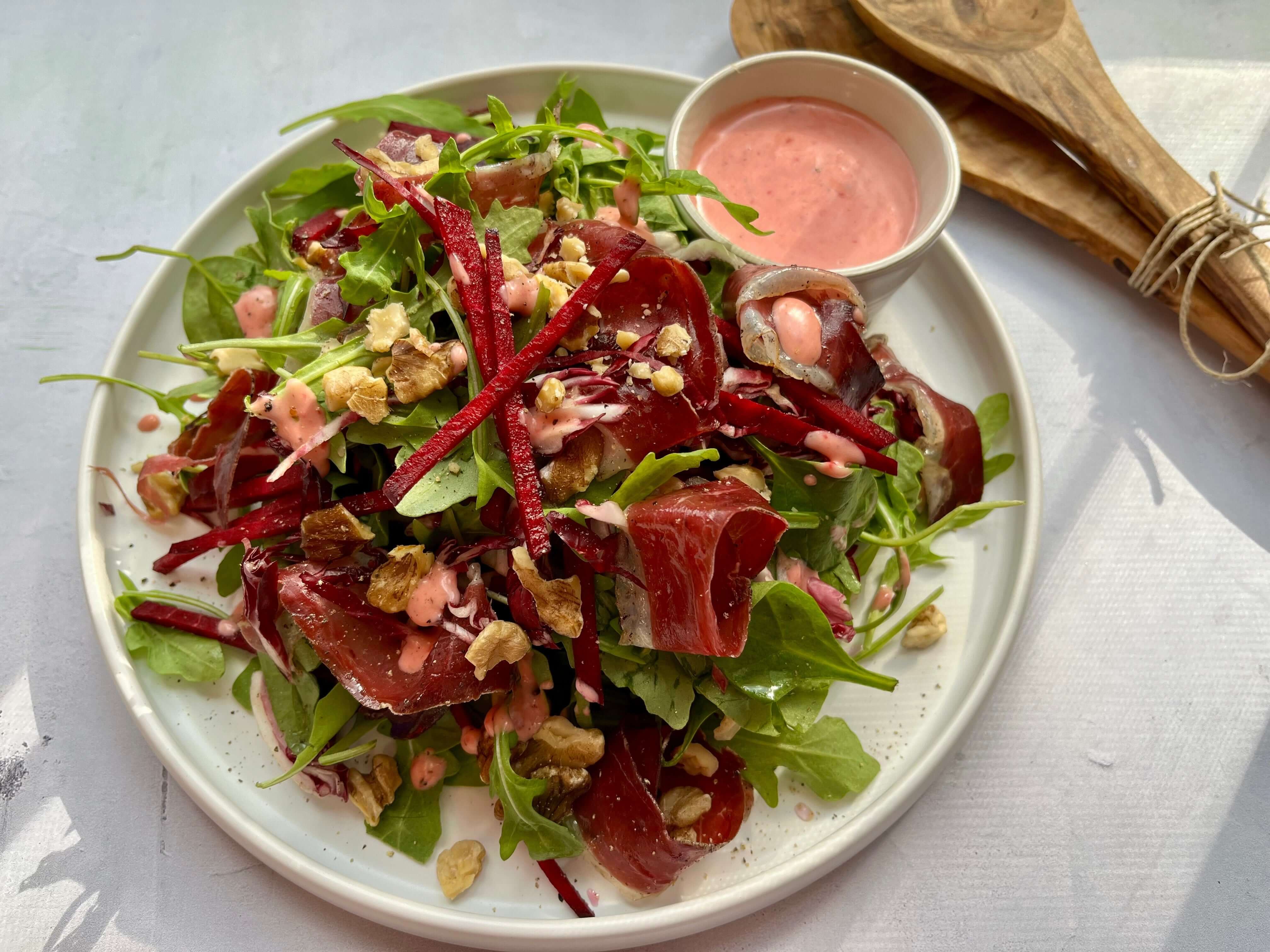 Salade d'automne avec roquette, betteraves rouges, prosciutto séché, noix et vinaigrette rosée