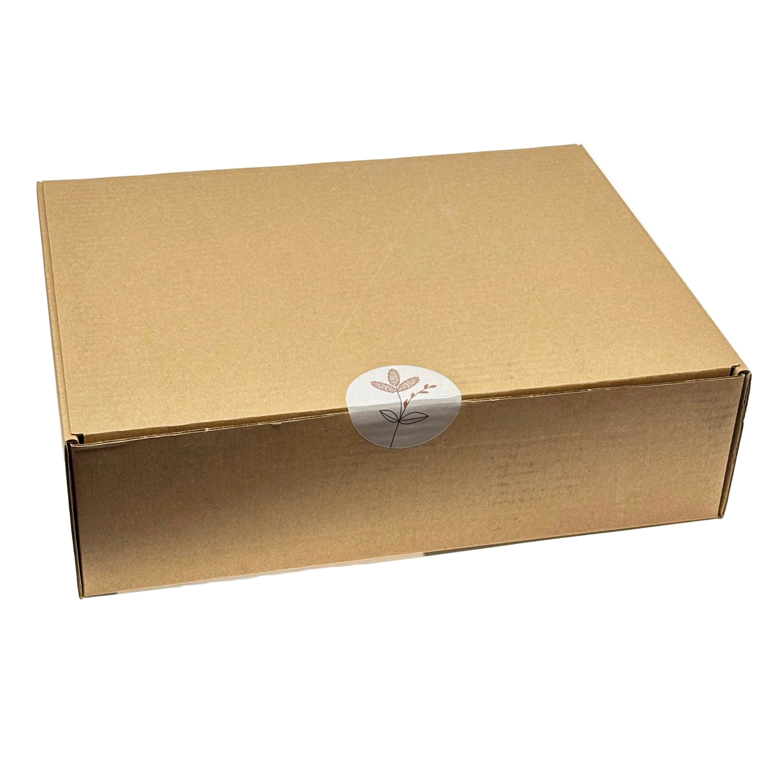 Boîte cadeau Racines Boréales en carton kraft fermée par un autocollant rond avec illustration botanique