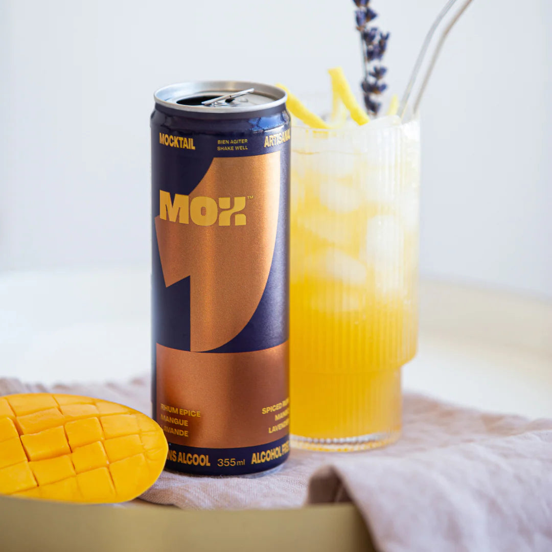 Canette et verre de MOX 1 avec mangue sur fond pâle