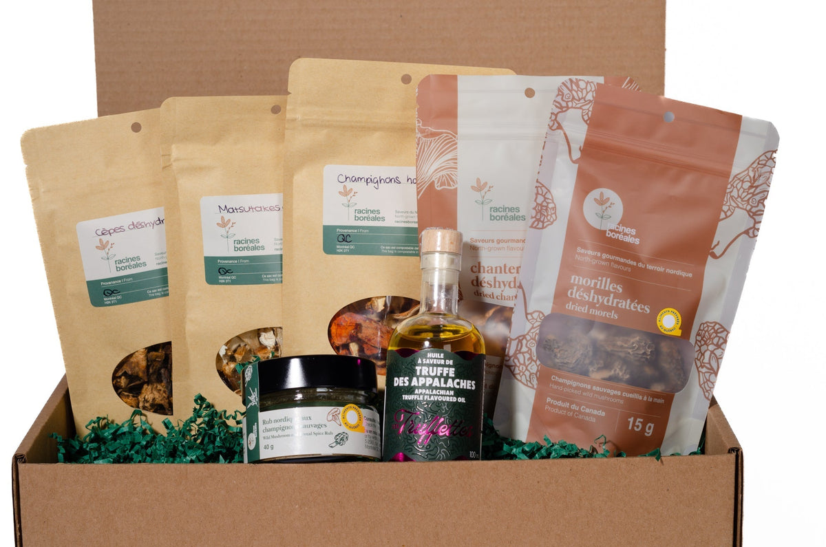 Boîte-cadeau Racines boréales ouverte contenant des champignons déshydratés, un rub d'épices, une huile aromatisée à la truffe et un pot de tartinade
